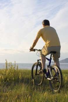 Man riding his bicycyle at the sea in the morning 