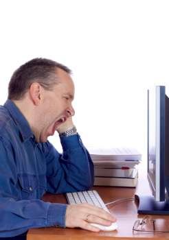 Tired man yawning at his computer 