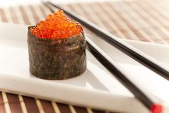 Salmon roe seaweed sushi roll on the bamboo table