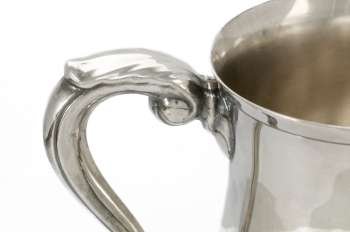 Handle detail on antique silver mug 