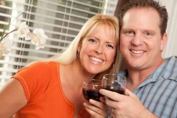 Happy Couple Enjoying a Glass of Wine the Kitchen.