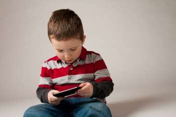 Cute little boy holding a portable video game 