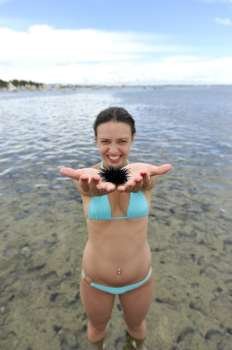 Woman holding an urchin on the beach in Brazil 
