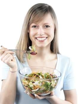 Portrait of young happy woman eating salad 