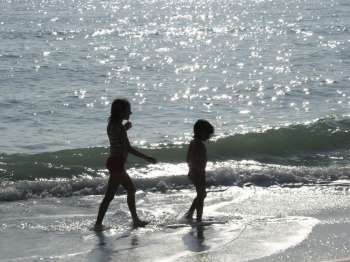 2 girls walking along the seashore