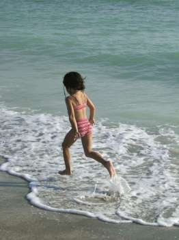 a little girl jumping in the sea