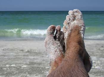 pair of feet covered in sand
