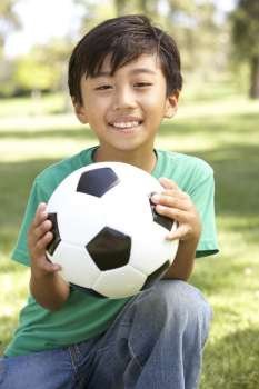 Portrait Of Young Boy In Park With Football