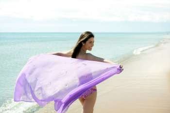 beautiful woman running on the beach, purple bikini