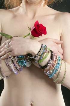 Nude redhead woman with jewelry and red rose