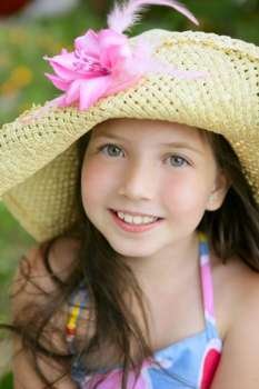 Closeup portrait of beautiful teen little girl with hat in the park