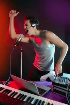 Dj with colorful light and music mixing digital equipment