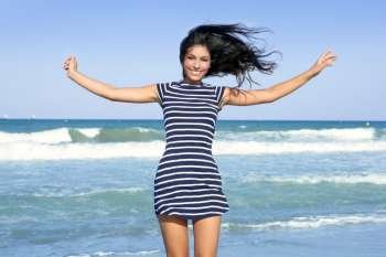 Beautiful summer indian brunette girl jumping on the blue beach