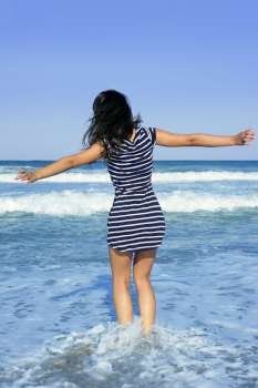 Beautiful summer indian brunette girl jumping on the blue beach