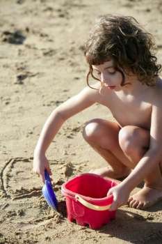 Beautiful little girl playing on the beach sand