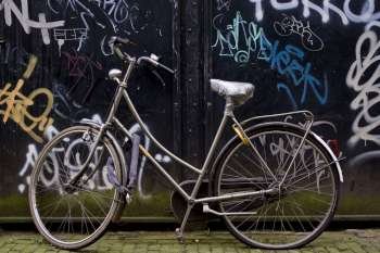 Bicycle parked by graffiti wall