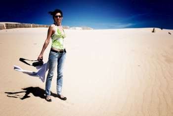 Woman stands on windswept Tarifa beach, Cadiz, Andalusia, Spain