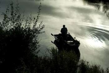 Man fishing from rowing boat, Scotland