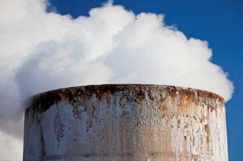 Close up shot of steam coming from the top of a chimney. Shot on location at a geothermal power station in Iceland.
