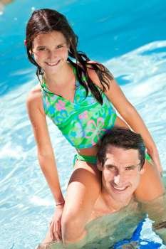 A father having fun with his daughter on his shoulders in a swimming pool