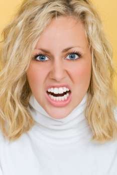 Studio shot of a beautiful young woman showing her teeth in anger
