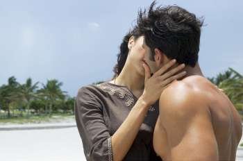 Close-up of a young woman and a mid adult man kissing each other
