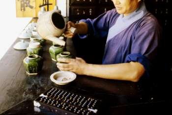 Mid adult man pouring tea into a cup, Hong Kong, China