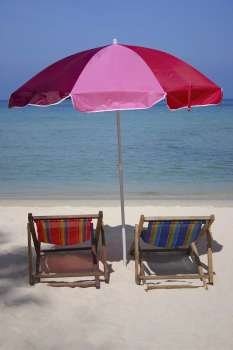 Two reclining chairs under a beach umbrella on the beach, Phi Phi Islands, Thailand