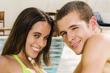 Portrait of a young couple smiling at the poolside