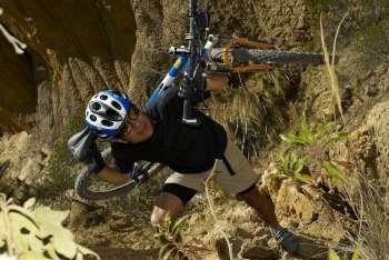 High angle view of a mid adult man carrying a mountain bike on his shoulders