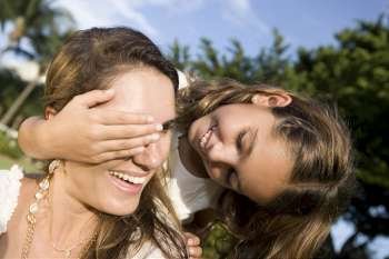 Close-up of a girl covering her mother´s eyes