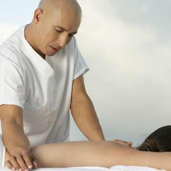 Mature man giving a young woman a back massage