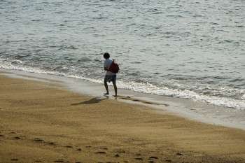 Rear view of a man walking on the beach, Plage du Miramar, Biarritz, France