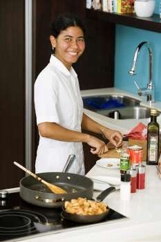 Portrait of a maid preparing food in the kitchen and smiling