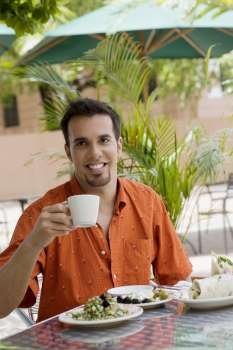 Portrait of a mid adult man drinking tea at a restaurant