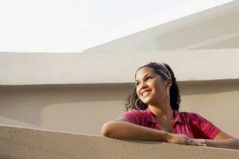 Low angle view of a young woman leaning against a wall
