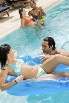 High angle view of two couples in a swimming pool