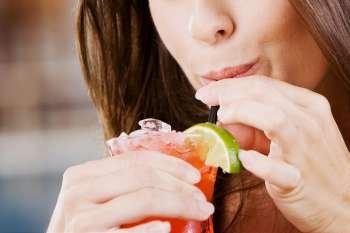 Close-up of a young woman drinking a glass of cocktail