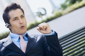 Close-up of a businessman wearing a bluetooth device and making a fist