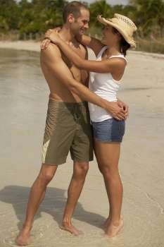 Young couple embracing each other on the beach