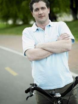 Portrait of a mid adult man standing with a bicycle