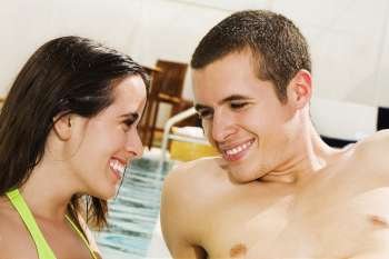 Close-up of a young couple smiling at the poolside