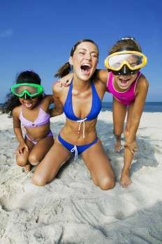 Two girls with a young woman playing on the beach