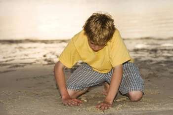Close-up of a teenage boy playing in sand