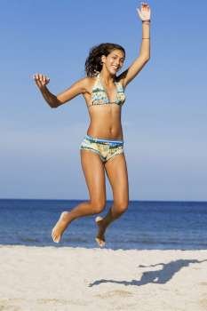 Teenage girl jumping on the beach
