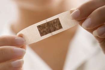 Mid section view of a female doctor holding an adhesive bandage