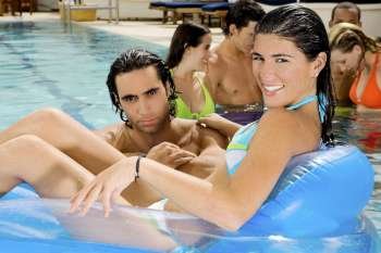 Portrait of a mid adult man and a young woman in a swimming pool