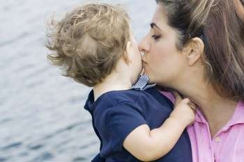 Close-up of a mid adult woman kissing her son