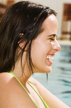 Side profile of a young woman smiling in a swimming pool