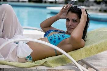 Side profile of a young woman relaxing on a lounge chair